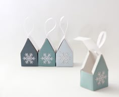 three small houses with snowflakes on them are sitting in front of each other