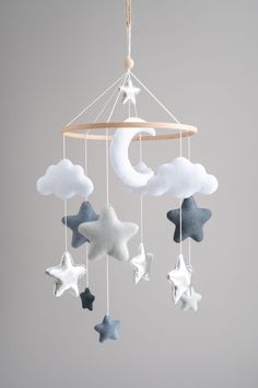 a baby crib mobile with stars and clouds hanging from it