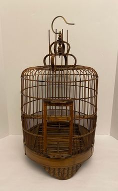 an antique birdcage is sitting on display