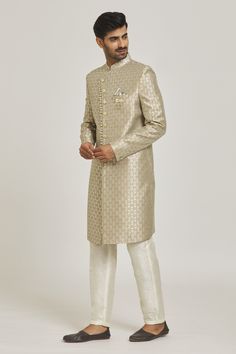 Beige overlap sherwani with floral pattern and patch pocket. Paired with cream aligarhi pant.
Components: 2
Type Of Work: Floral
Neckline: Mandarin
Sleeve Type: Full
Fabric: Sherwani: Banarasi Jacquard, Pant: Dupion Art Silk
Color: Beige
Other Details: 
Note: Pocket square and brooch worn by the model is not for sale
Occasion: Wedding - Aza Fashions Metallic Pattern, Pocket Square, Aza Fashion, Sleeve Type, Patch Pocket, Floral Pattern, Types Of Sleeves, For Men, Silk