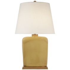 a yellow table lamp with a white shade