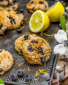 lemon blueberry muffins on a baking sheet with fresh flowers and lemon slices