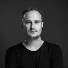 a black and white photo of a man with his arms crossed looking at the camera