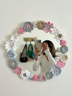 a woman taking a selfie with her cell phone in front of a flowered mirror