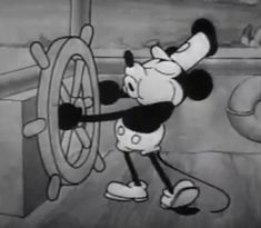 the mickey mouse cartoon is trying to get out of the ship's steering wheel