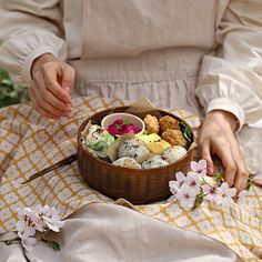 a woman is holding a basket full of food