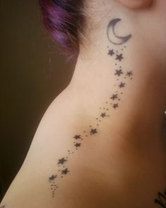 the back of a woman's neck with stars and moon tattoos