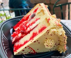 a slice of cake with white and red frosting