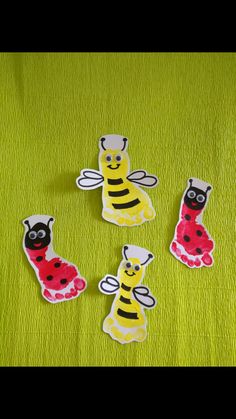 four stickers that are on top of a green surface with a ladybug and bee