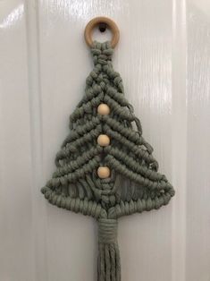 a green christmas tree hanging on a white door with wood ornaments around the top and bottom