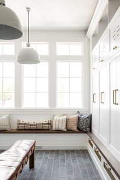 a white room with two windows and a bench