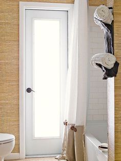 a bathroom with a white door and towel rack on the wall next to a bathtub