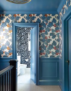 a hallway with blue walls and floral wallpaper