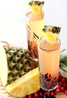 two glasses filled with pineapple punch on top of a table