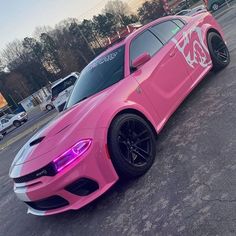 a pink sports car parked in a parking lot