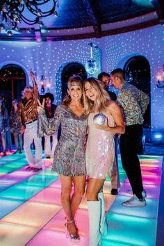 two women are standing on the dance floor in sequin dresses and white cowboy boots