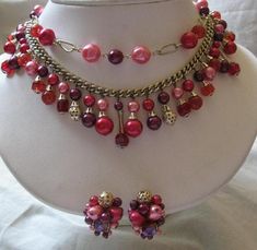 Gorgeous Retro Jackie-O Fashion! A wonderful, eclectic mix: fuchsia facetted glass iris finish beads glass beads mixed with nice quality pink/purple/ /fuchsia round faux pearls and clear plastic beads make up this double strand necklace from the 60's. The lower strand is made up of dangling sets of pearls, accented with goldtone bead caps on a lightweight goldtone metal chain. Matching clip earrings have clusters of beads and a few small dangling pearls on the bottom. Perfect finishing touch to Pink Large Beads Jewelry For Party, Pink Large Beaded Jewelry For Parties, Pink Costume Jewelry Beaded Necklaces For Party, Pink Czech Glass Jewelry For Party, Pink Czech Glass Party Jewelry, Festive Pink Beaded Necklace With Dangling Beads, Dangly Necklace, Double Strand Necklace, Plastic Beads