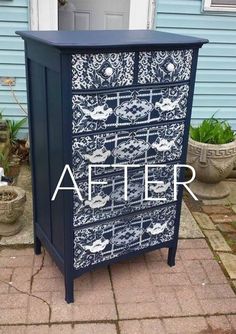 a blue and white painted chest of drawers in front of a house with potted plants