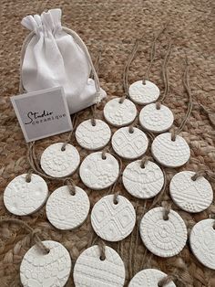 white ceramic ornaments are on the floor next to a drawstring bag and tag