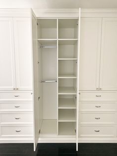 an empty closet with white cabinets and drawers