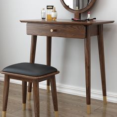 a wooden vanity table with a mirror and stool in front of it on a hard wood floor