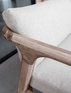 a close up view of a wooden armrest on a white couch in a living room