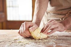 a man is kneading dough into a ball on the counter top with his hands