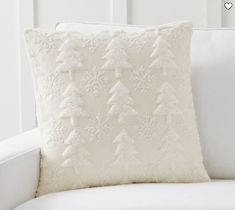 a white couch with a christmas tree pillow on it