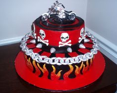 a red cake with skulls and chains on it's top is sitting in front of a white background