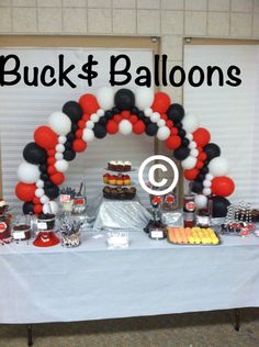 a table topped with balloons and desserts next to a sign that says buck & balloon's