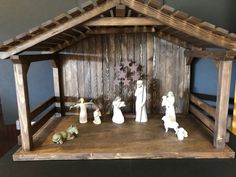 a wooden nativity scene with figurines in it