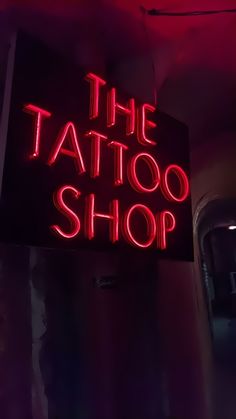 the tattoo shop sign is lit up in red