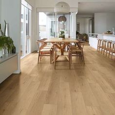 a large dining room with wooden floors and white walls, along with an open floor plan