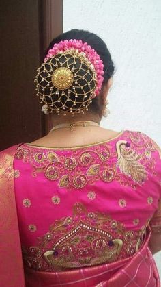 the back of a woman's pink saree with gold work on her neck