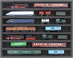 a collection of toy trains on display in a black case with white border around the edges