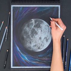 someone is drawing the moon with colored pencils