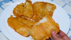 someone is holding up some fried food on a white plate with blue and white checkered table cloth