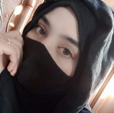 a woman wearing a black hood and ring