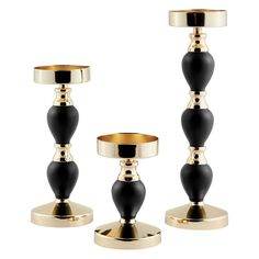 three black and gold candlesticks are shown on a white background, with one candle holder in the middle