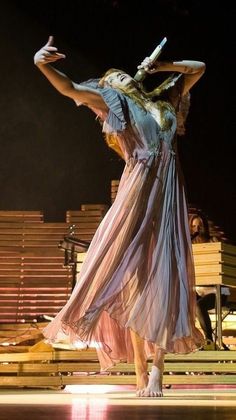 a woman in a dress is dancing on stage