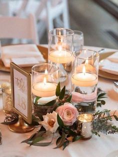 a table with candles, flowers and other items on it for a wedding or special event