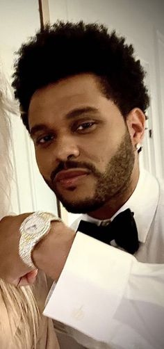 a man in a tuxedo is adjusting the watch on a woman's wrist