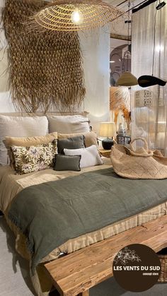 a bed with pillows and blankets on top of it in a room filled with hanging lights