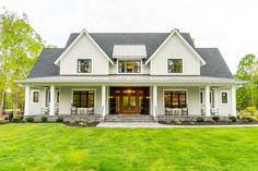 a large white house sitting on top of a lush green field