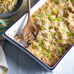 a casserole dish with meat and vegetables in it next to a wooden spoon