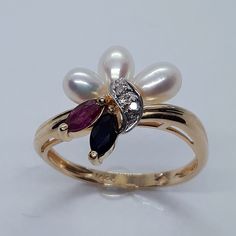 This handmade, beautiful  ring has been expertly crafted in warm 14k yellow gold and genuine pearls, Sapphire, Ruby and Diamonds. This gorgeous ring will make a great special occasion/ birthday gift. All of my jewelry is handmade from scratch, one item at a time as I like to make sure I am producing a high quality item. A tracking shipping number will be provided to you once the ring has been shipped. 3 Pearl measurements: 5.65x4.35 mm 1 Marquise Sapphire: 5x2.5 mm 1 Marquise Ruby: 5x2.5 mm 2 Di Anniversary Yellow Gold Multi-stone Pearl Ring, White Pearl Ring, Gold Pearl Ring, Ruby Ring, White Ring, Pearl Ring, Pearl White, Stone Rings, Sapphire Ring