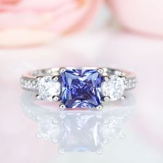 Gorgeous Princess Tanzanite Ring ►Made of sterling silver, rhodium plated (S925) ►Center stone: Tanzanite Color: Purple Gemstone Creation: Simulated Cut: Princess Gem size: 6.0 mm Carat Weight: 1.2 ct. (approx.) ►Accented with simulated diamonds (CZ) Cut: Round Gem size: 1.0 mm- 4.0 mm Color: Colorless ►Bands width: 2.4 mm ✓ 100% Nickel-Free ✓ Hypoallergenic ✓ Comfort Fit ✓ Free Ring Box ✓ Free USA Shipping ✓ Ready to ship next business day Etsy Engagement Rings, Popular Engagement Rings, Tanzanite Ring, Sterling Silver Engagement Rings, Gemstone Engagement, Alternative Engagement Rings, Wedding Ring Designs, December Birthstone, Fine Jewelry Collection