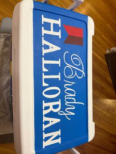 a blue and white cooler sitting on top of a wooden floor