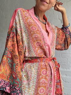 "This is one of a kind patchwork, upcycled silky robe Made free size with wrap tie closing and wide kimono sleeves  Easy and fun to wear around the house or outside as a urban boho style,  flowy kardigan with jeans and tshirt  It is very comfy and feels soft and light  the material is colourful indian saree silk made into this unique stylish over all MEAESURE free size length 55\" MATERIAL *polyester and silk * no lining more avaialable at  https://www.etsy.com/shop/AltheaStores? CARE INSTRUCTIO Pink Hippie Kimono For Summer, Summer Hippie Pink Kimono, Pink Bohemian V-neck Kimono, Hippie Style Multicolor V-neck Kimono, Multicolor Kimono Sleeves Robe For Festival, Pink Boho Print Kimono For Festival, Multicolor Wrap Kimono For Festivals, Spring Festival Kimono With Patchwork, Colorful Summer Kimono With Kimono Sleeves