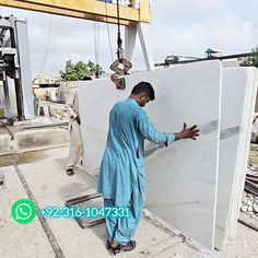 a man standing next to a white refrigerator in the middle of an unfinished building under construction